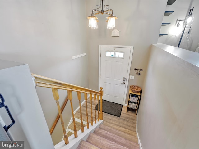 foyer with a chandelier, stairway, light wood-type flooring, and baseboards