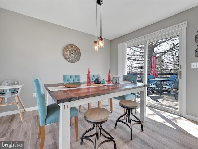 dining room with baseboards and light wood finished floors