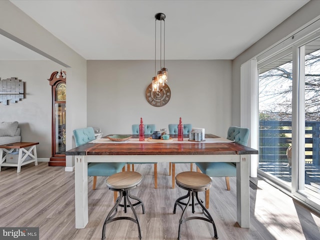 dining space featuring light wood finished floors and baseboards