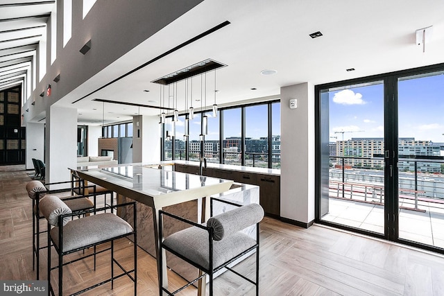 interior space with light countertops, floor to ceiling windows, a city view, and hanging light fixtures