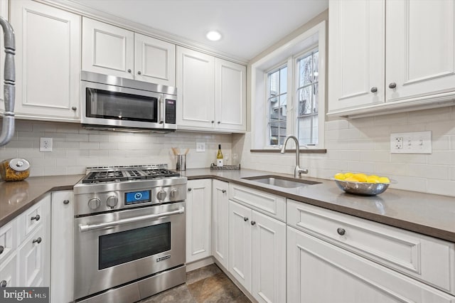 kitchen with white cabinetry, appliances with stainless steel finishes, decorative backsplash, and a sink