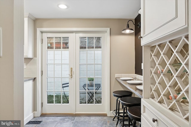 doorway to outside featuring french doors, visible vents, and baseboards