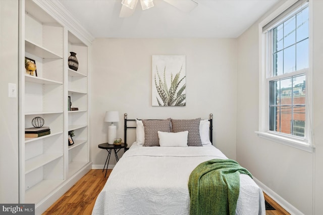 bedroom featuring a ceiling fan, baseboards, and wood finished floors