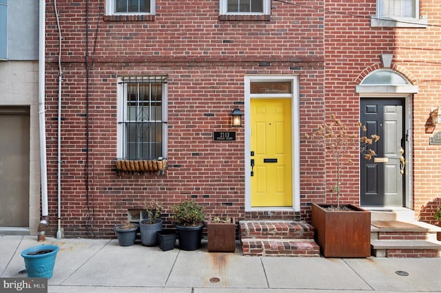 property entrance with a patio area and brick siding