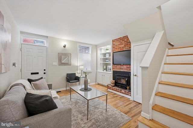 living room with a wealth of natural light, wood finished floors, and stairs