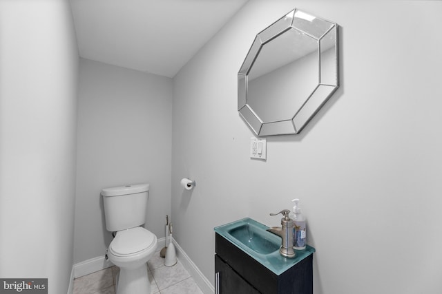 bathroom featuring tile patterned flooring, vanity, toilet, and baseboards