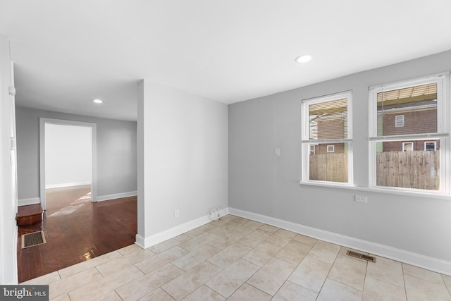 unfurnished room with recessed lighting, visible vents, and baseboards