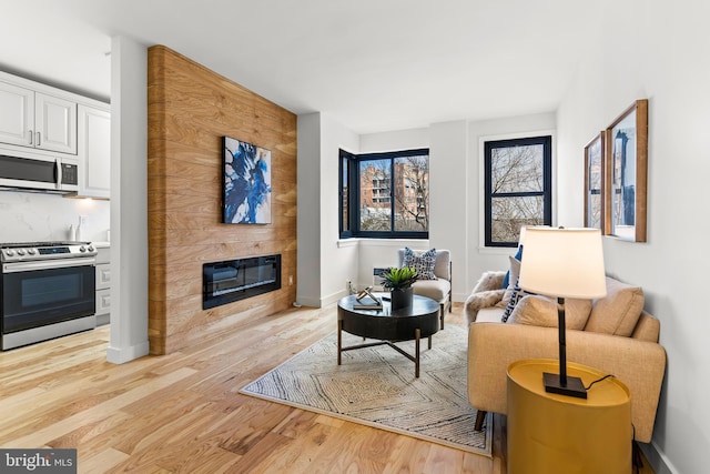 sitting room featuring light wood-type flooring, a fireplace, and baseboards