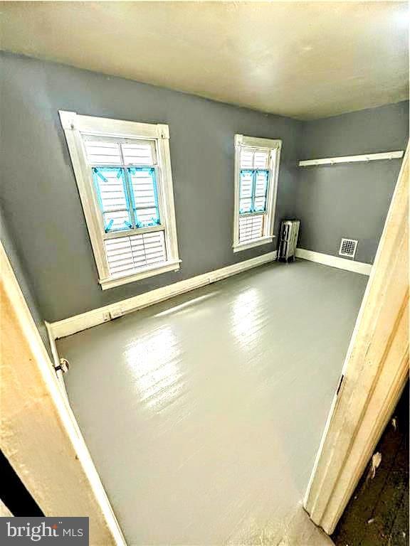 interior space with baseboards, visible vents, and radiator heating unit