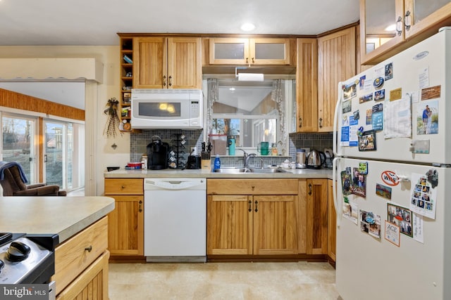 kitchen with white appliances, light countertops, a sink, and backsplash