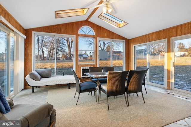 sunroom / solarium with lofted ceiling with skylight, plenty of natural light, and ceiling fan