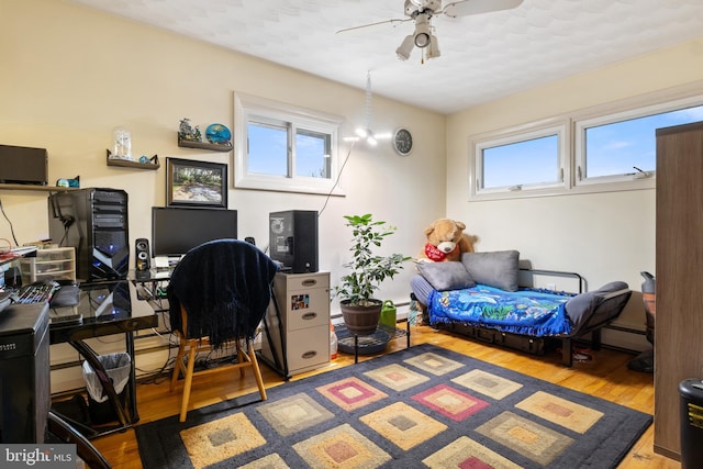 office space featuring ceiling fan, baseboard heating, and wood finished floors