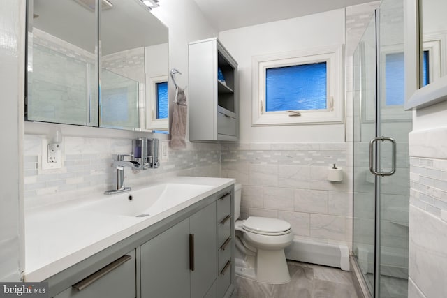 bathroom with toilet, a shower stall, tile walls, and vanity