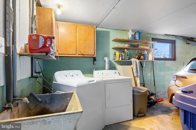 washroom featuring separate washer and dryer, a sink, and cabinet space