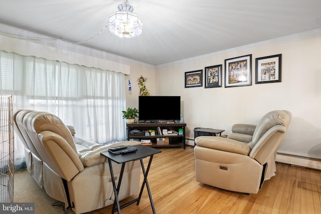 living room featuring ornamental molding, a baseboard radiator, an inviting chandelier, and wood finished floors