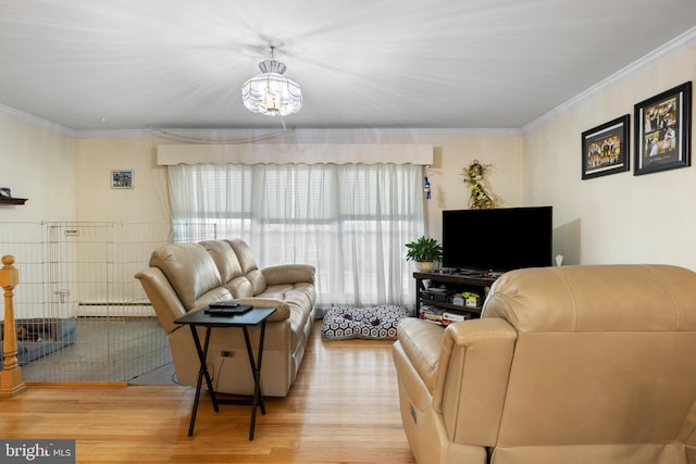 living area with baseboard heating, light wood-style flooring, and crown molding