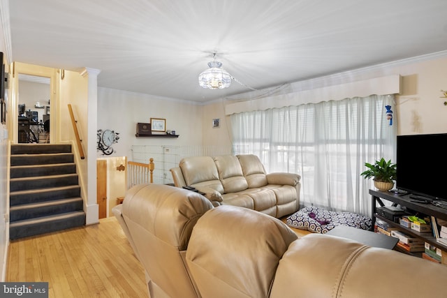 living room with ornamental molding, a chandelier, stairway, and light wood finished floors