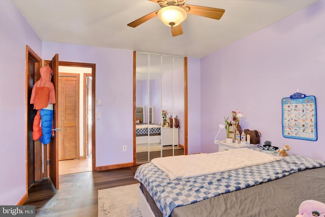 bedroom with ceiling fan, wood finished floors, and baseboards