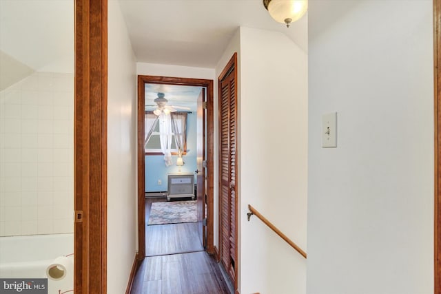 corridor with dark wood-style floors and an upstairs landing