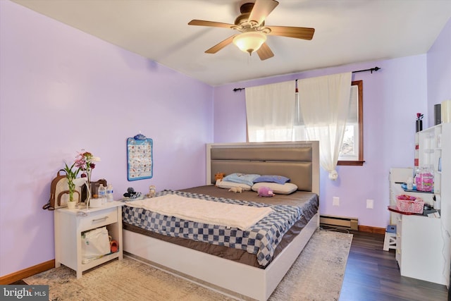 bedroom featuring ceiling fan, baseboards, baseboard heating, and wood finished floors