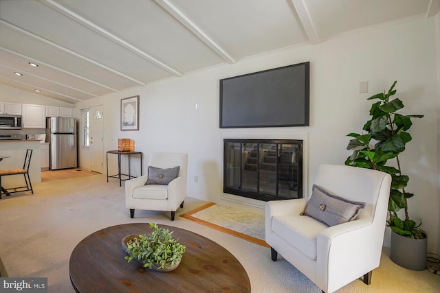 living room featuring lofted ceiling with beams, light colored carpet, and a glass covered fireplace