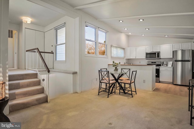 dining area featuring lofted ceiling with beams, stairway, light carpet, and recessed lighting