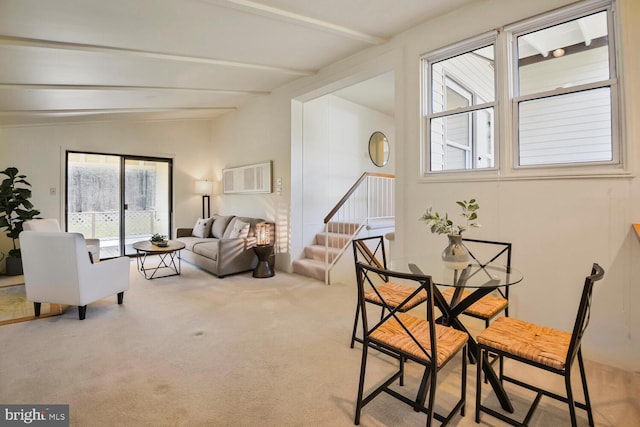 dining area featuring stairway, vaulted ceiling with beams, and carpet flooring