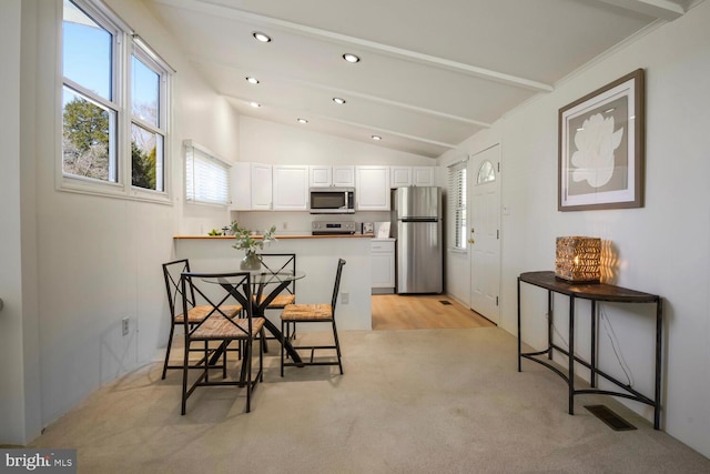 dining room with vaulted ceiling, recessed lighting, light colored carpet, and visible vents