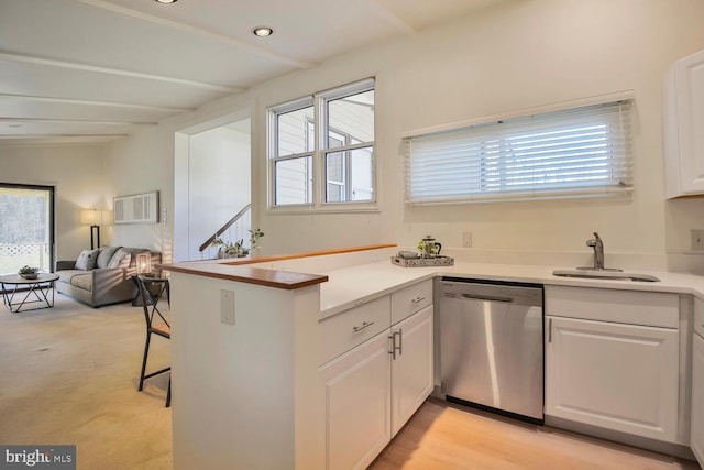 kitchen with a healthy amount of sunlight, dishwasher, white cabinetry, and a sink