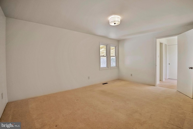 empty room featuring visible vents and carpet floors