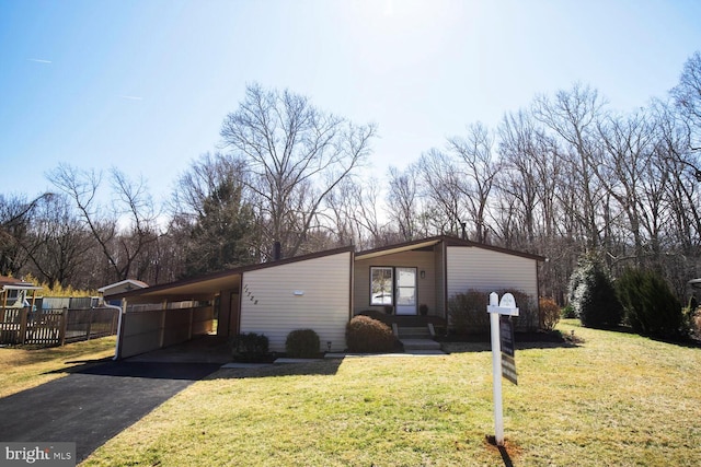 view of front of house with a carport, aphalt driveway, and a front yard