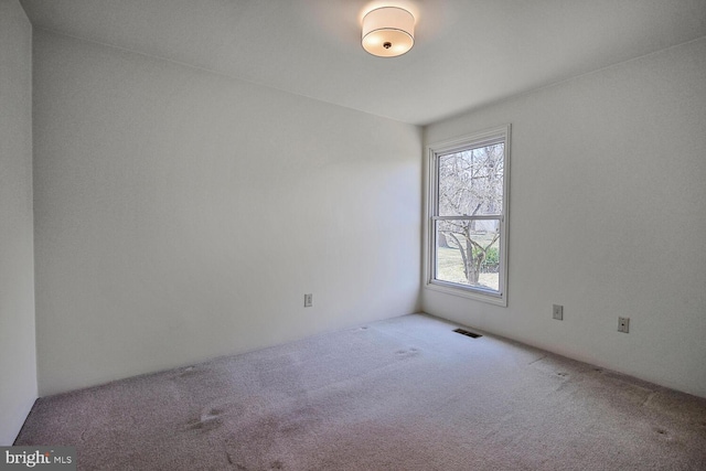 empty room featuring carpet and visible vents