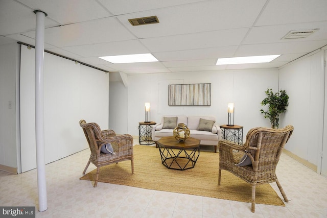 living area featuring visible vents and a drop ceiling