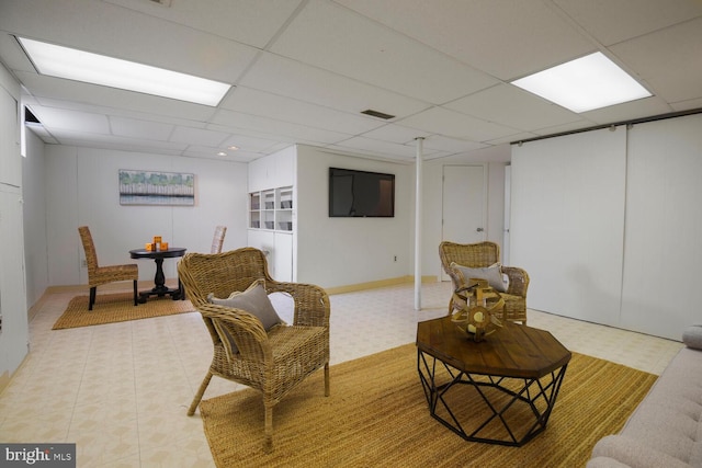 sitting room featuring a drop ceiling, visible vents, and light floors