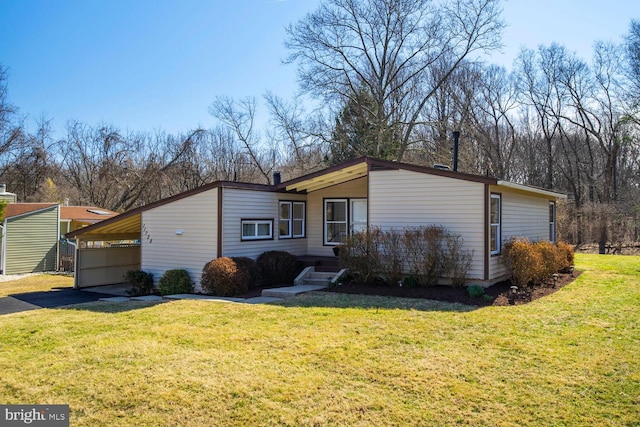 view of front facade with an attached carport, a front lawn, and driveway