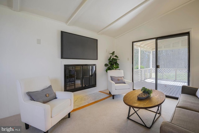 living area with a glass covered fireplace and vaulted ceiling with beams