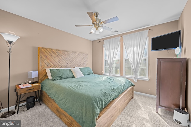 bedroom featuring a ceiling fan, light colored carpet, visible vents, and baseboards