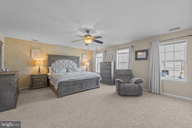 bedroom featuring light carpet, baseboards, visible vents, and a ceiling fan