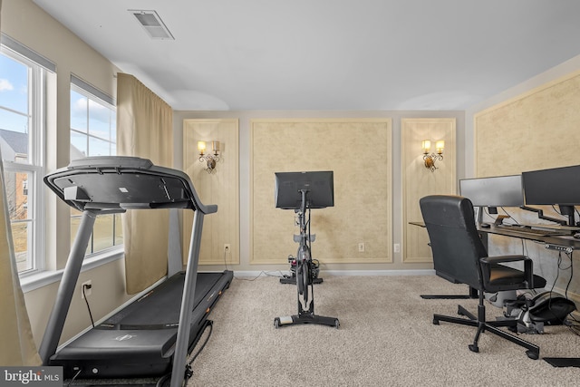 workout area with baseboards, visible vents, and light colored carpet