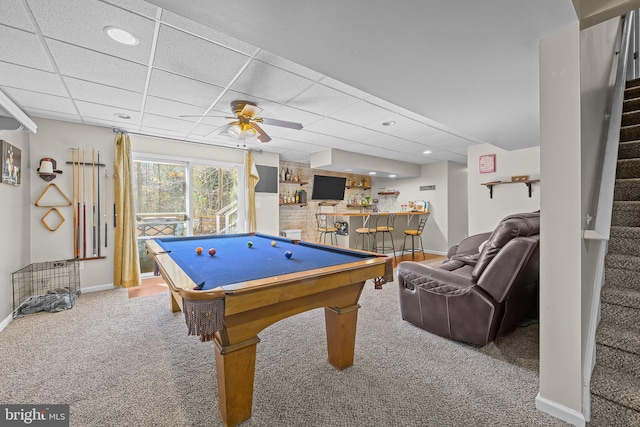 playroom featuring baseboards, carpet floors, a drop ceiling, ceiling fan, and a bar