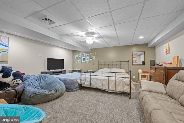 bedroom with carpet floors, a drop ceiling, visible vents, and a ceiling fan