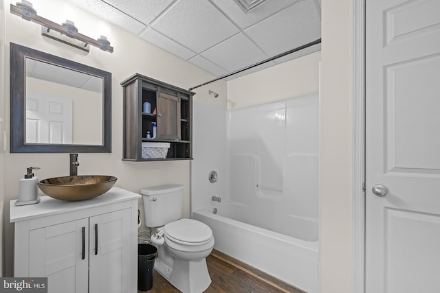 full bathroom with a paneled ceiling, toilet, vanity, shower / tub combination, and wood finished floors