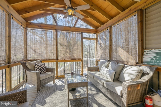 sunroom / solarium featuring lofted ceiling with beams, wooden ceiling, and a ceiling fan