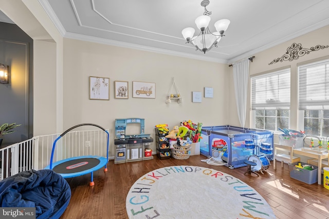 playroom with a notable chandelier, crown molding, and wood finished floors