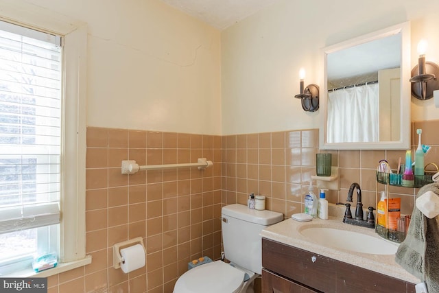 bathroom with tile walls, vanity, and toilet