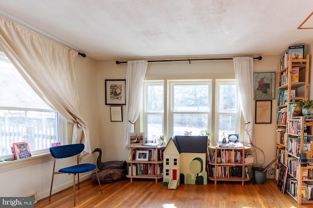 sitting room featuring a textured ceiling and wood finished floors