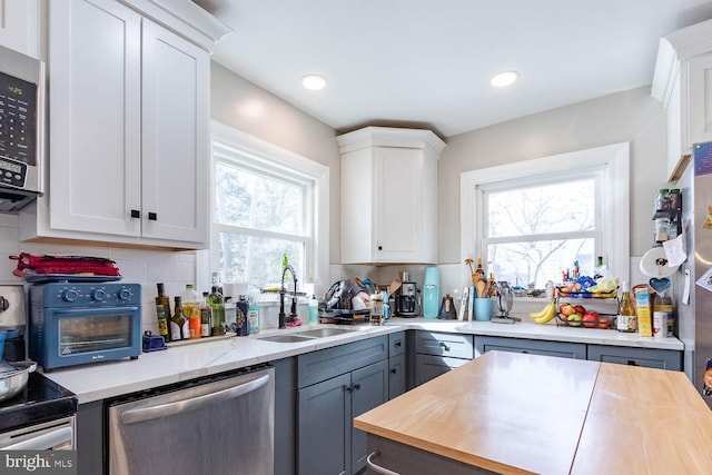 kitchen with stainless steel appliances, white cabinets, and a sink