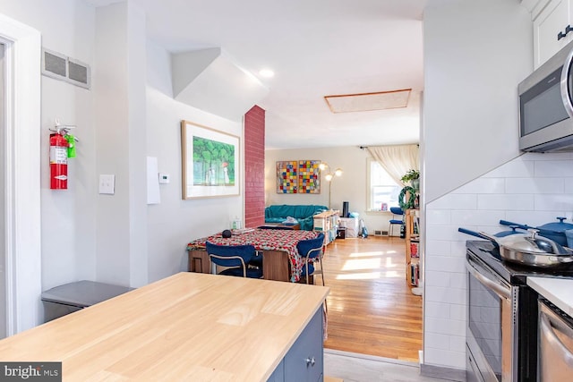 kitchen with visible vents, open floor plan, light countertops, appliances with stainless steel finishes, and light wood-type flooring