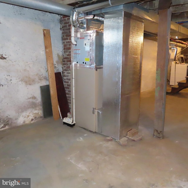 unfinished basement with heating unit and stairway