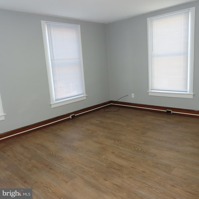 spare room with wood finished floors and baseboards